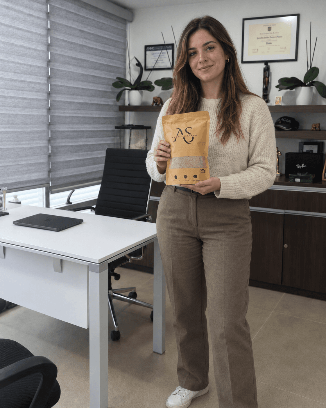 Mujer con suéter claro y pantalón marrón sosteniendo la fibra