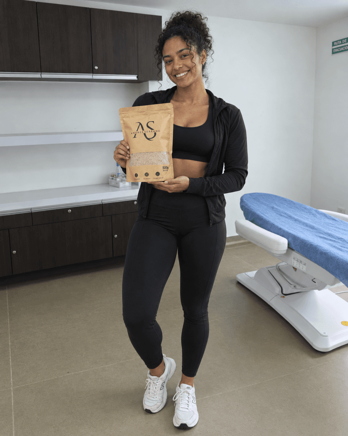 Mujer con ropa deportiva negra sosteniendo una bolsa de fibra