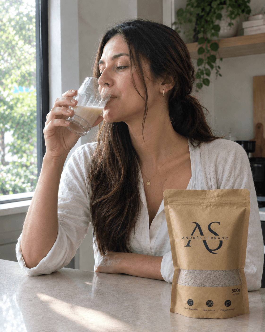 Una mujer bebe la fibra preparada, junto a la bolsa del producto